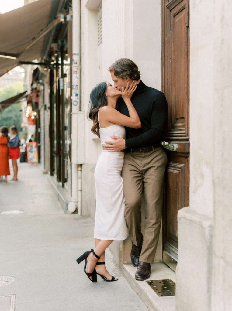 A newly engaged couple kissing on streets of Paris 