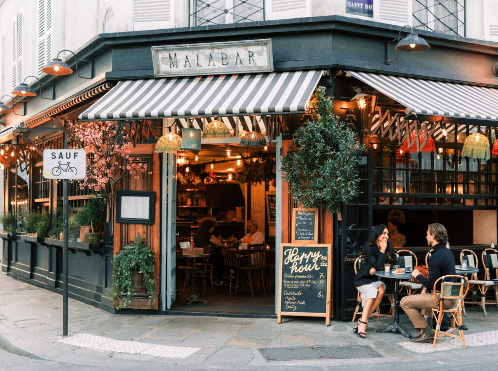 An engaged couple sitting in a cafe in Paris