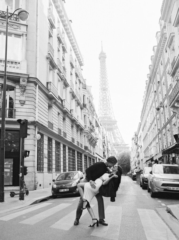 A couple kissing on streets of Paris with Eiffel Tower at the background 