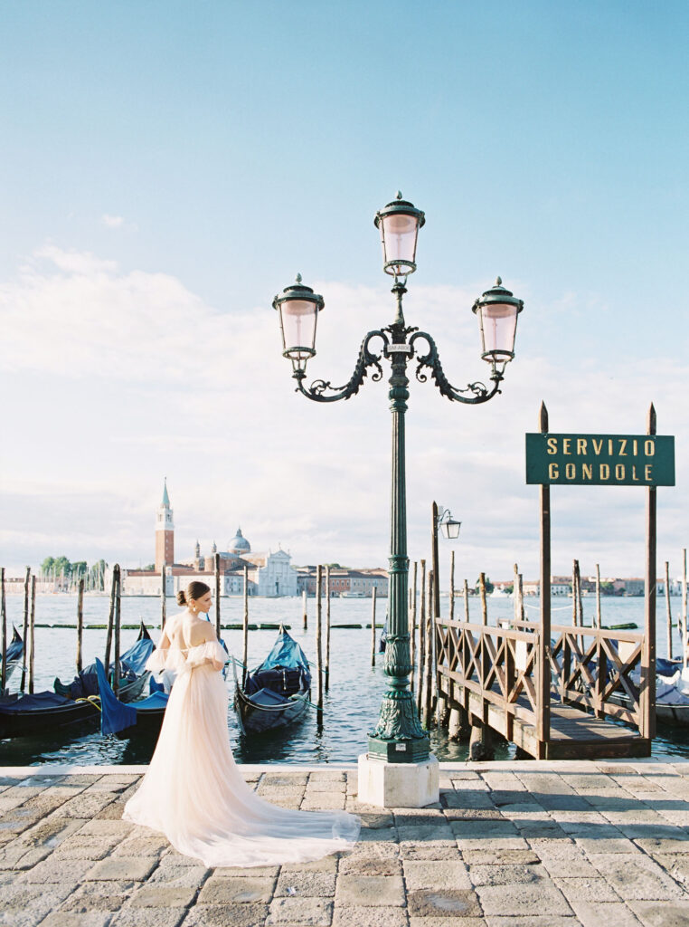 A young woman standing in front of Gondolas in Venice