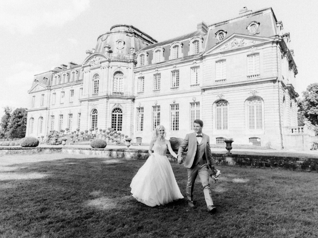 bride and groom walking at Chateau De Champlatreux 