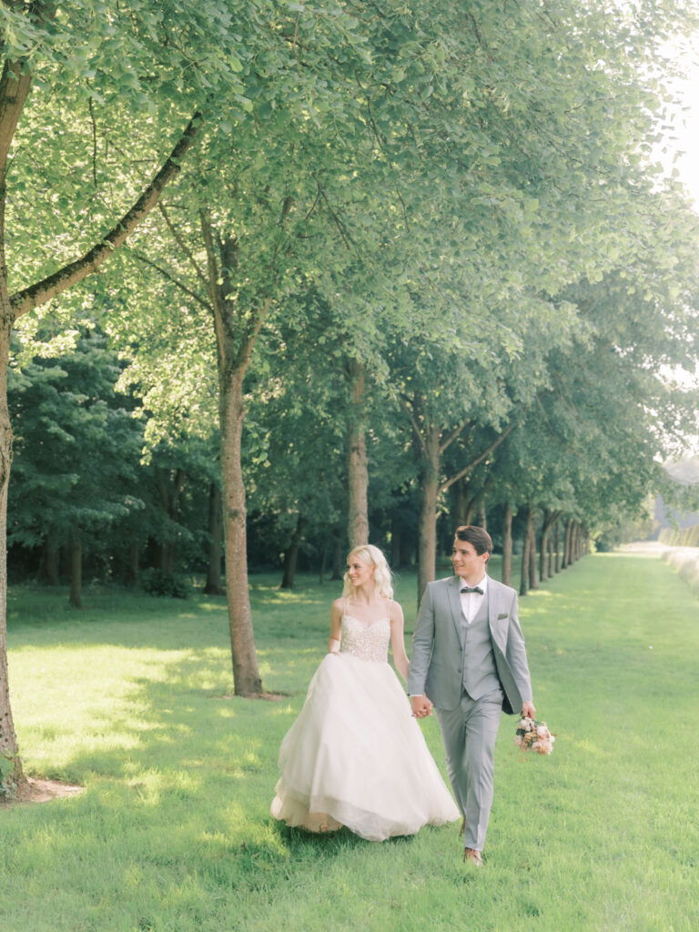 bride and grrom walking at Chateau De Champlatreux 